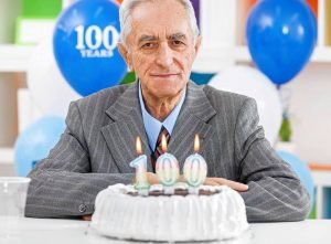 Healthy 100 year old man with birthday cake
